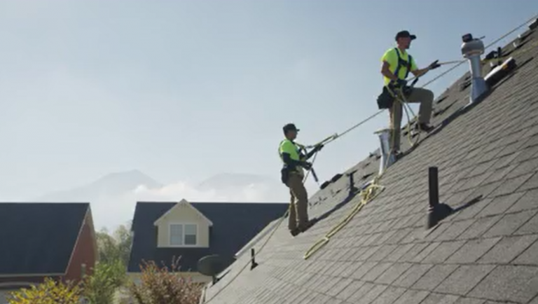 Roofing professionals installing asphalt shingles on a residential roof for DaVinci Roofing Corp