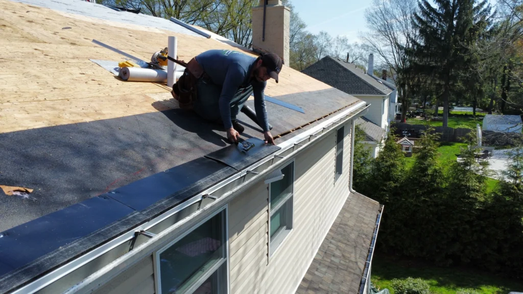 Roofing technician installing drip edge on a residential roof in Yardley, PA.